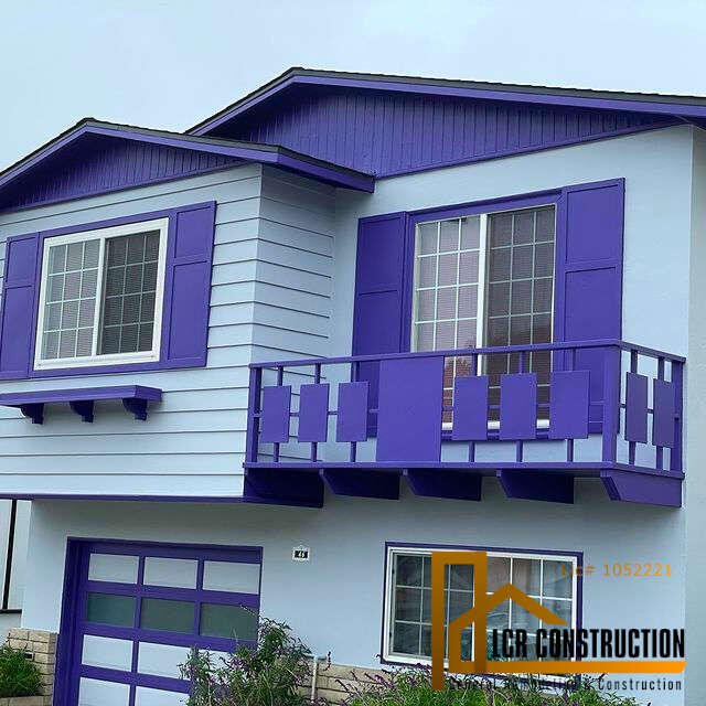 An exterior remodeling project transformed this house with purple siding and blue shutters.