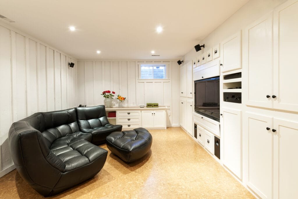A living room with a black leather couch and tv, offering comfortable seating for entertainment services.